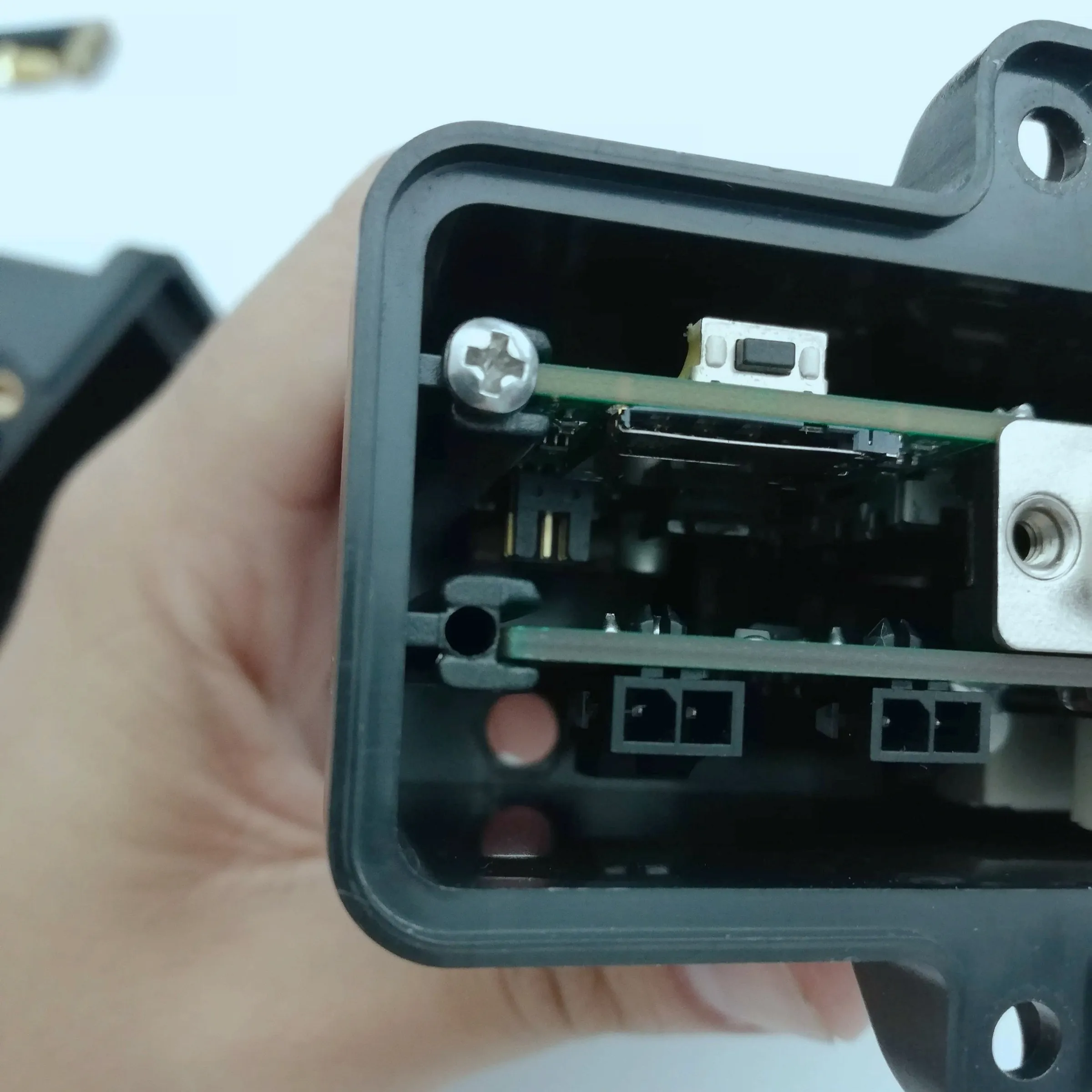 Open prototype enclosure held in hand showing internal electronics