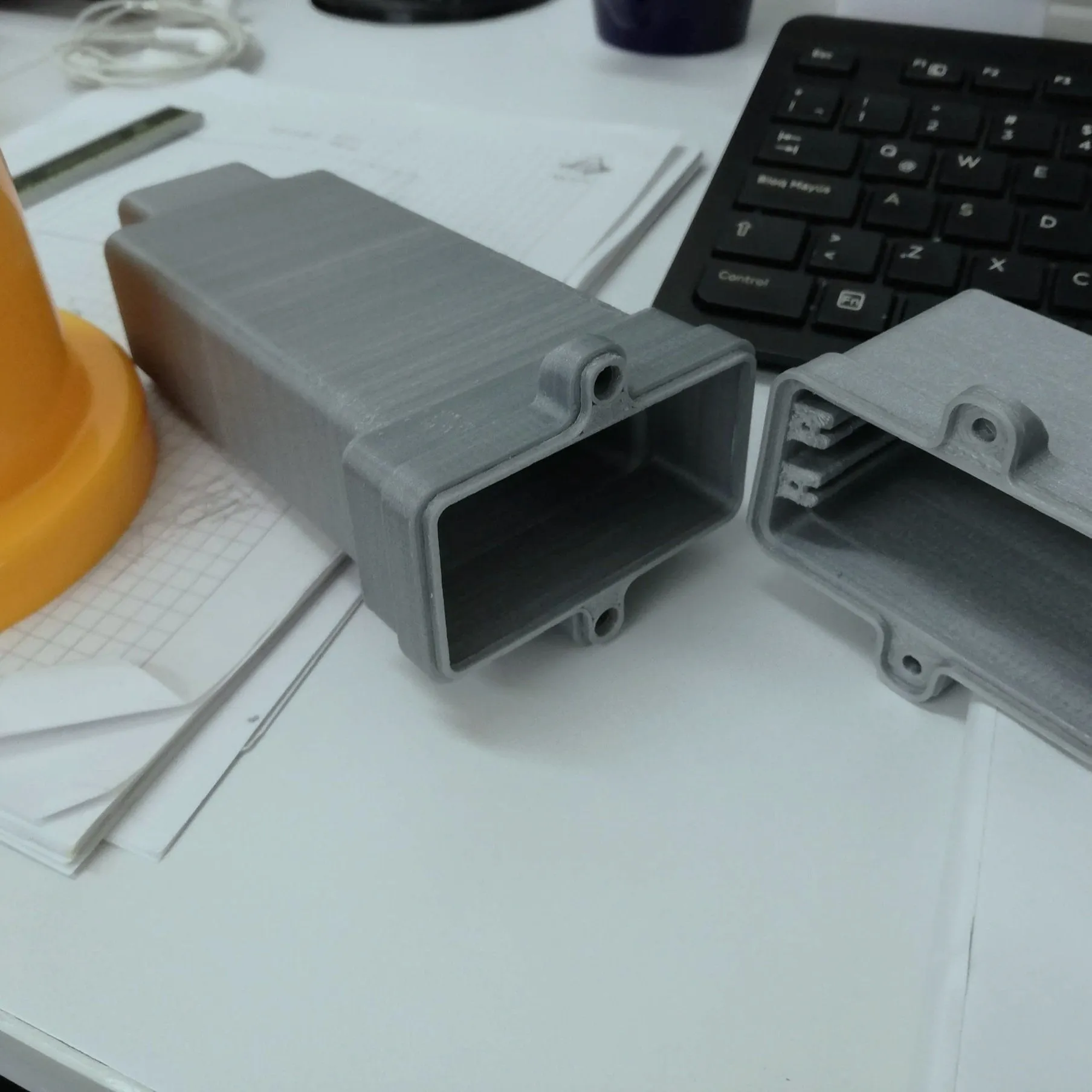 Grey 3D-printed enclosure prototypes on workbench